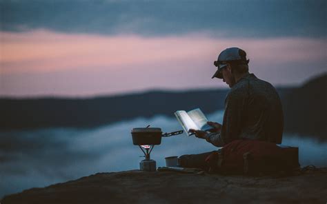 Download Hiker Reading Book In Mountain Wallpaper | Wallpapers.com