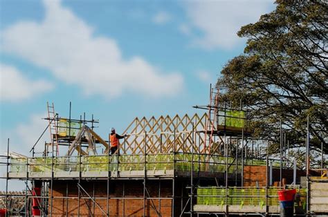 Premium Photo | Worker placing roof joists in to position and fixing ...