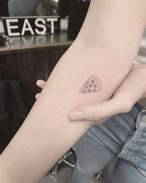 Single needle pizza slice tattoo located on the inner