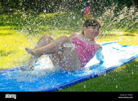 little girl sliding on a water slide Stock Photo - Alamy