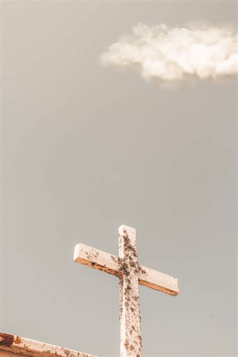 a cross on top of a building with a cloud in the sky behind it,