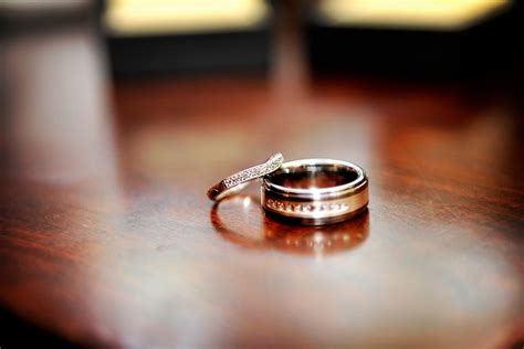 Artistic engagement ring wedding band photo, captured on dark mahogony