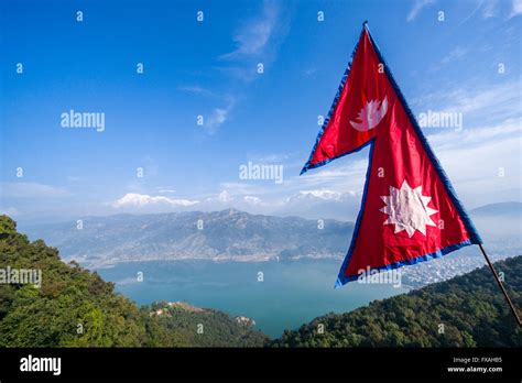 Nepali national flag waving high above the Phewa Lake and Pokhara ...