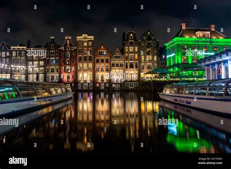 Dancing houses on Amsterdam Damrak canal at night Stock Photo - Alamy