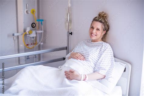 Portrait of pregnant woman relaxing on hospital bed Stock Photo | Adobe ...