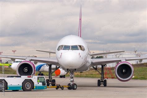 Pushback passenger jet aircraft procedure. Low-profile vehicle called ...