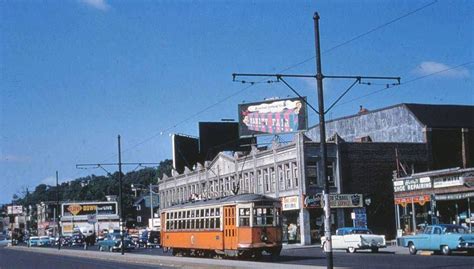 an orange trolley is going down the street in front of some buildings ...