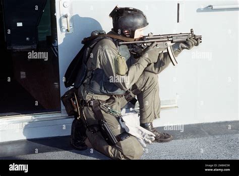 A U.S. Navy SEAL, in firing position armed with an MP5-N sub-machine ...