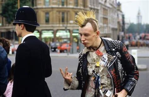 British punk politely gestures behind a policeman's back in 1983. : r/punk