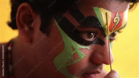 Close up of a traditional Kathakali dancer giving final touches on his ...