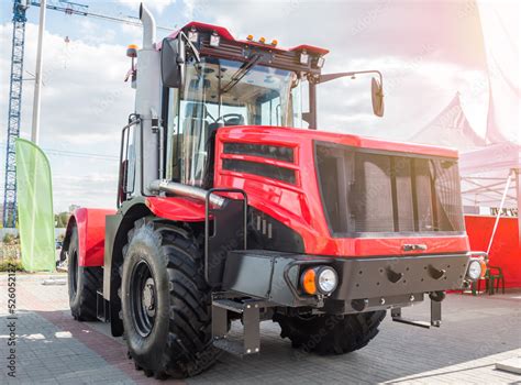 Red heavy duty wheeled tractor on a parking lot Stock Photo | Adobe Stock