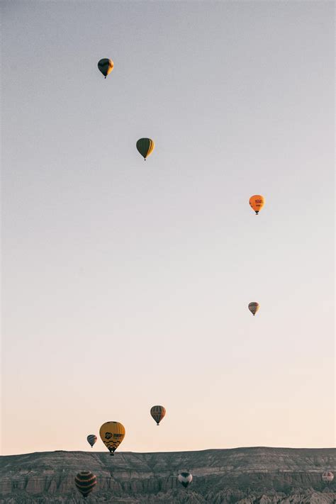 Hot air balloons flying in sky over highlands in daytime · Free Stock Photo