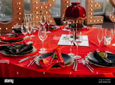 Guests table setting for banquet in black, red and gold style. Elegant ...