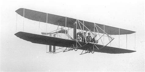 an old airplane flying in the sky with two men inside it's wings and ...