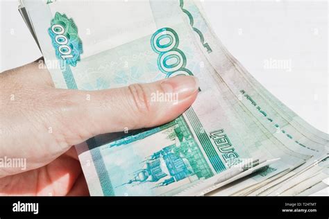 A pack of 1000 ruble banknotes compressed in hand Stock Photo - Alamy