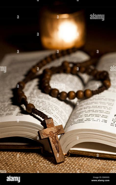 Open Holy Bible, Wooden Rosary Beads and Candle Stock Photo - Alamy