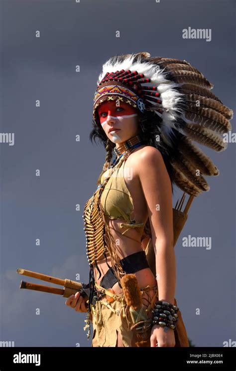 A native American Indian woman is seen standing in front of grey ...