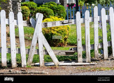 Broken fence. Damaged weathered white picket fence with broken rails ...