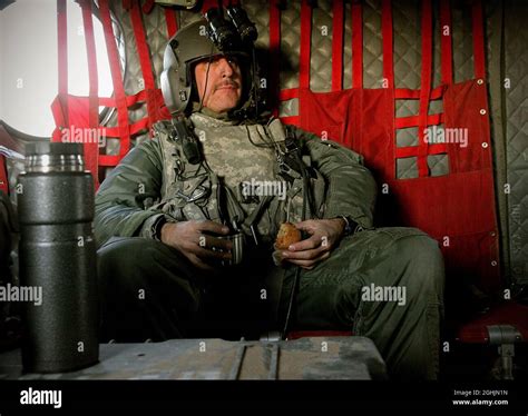 A CH-47 Chinook helicopter crew chief takes a break to drink coffee and ...