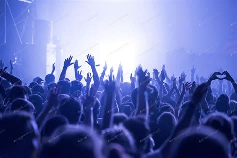 Crowd at a music concert, audience raising hands up