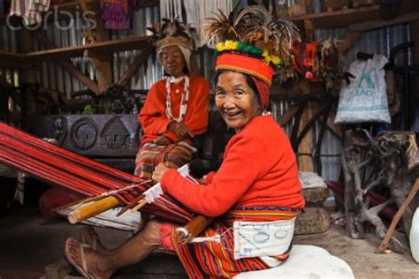 Ifugao woman in traditional clothing weaving textiles on a hand loom ...