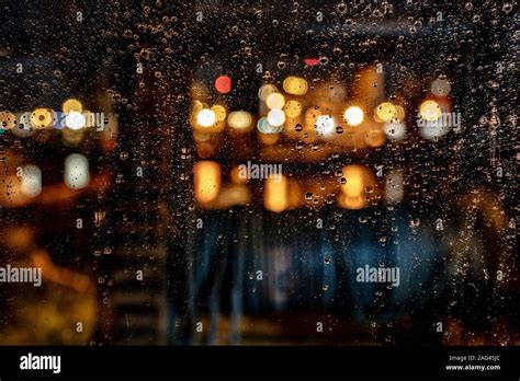 Beautiful shot of water drops on a window during a rainy night with a ...