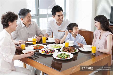 Chinese family of three generations having dinner together — oriental ...