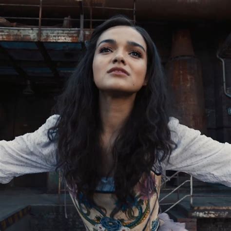 a woman with long black hair standing in front of an industrial ...