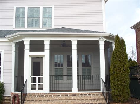 Hip style roof screened in porch with decorative columns and iron rails ...