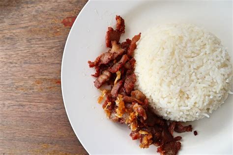 Premium Photo | Fried pork with garlic topped with rice