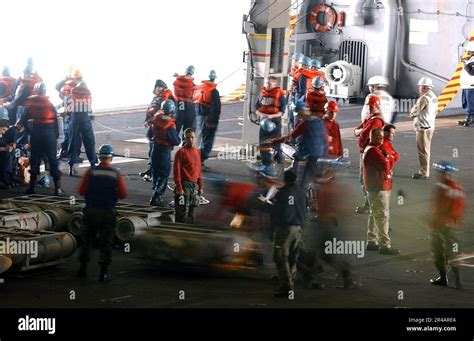 US Navy Crew members aboard USS Nimitz (CVN 68), transport weapons and ...