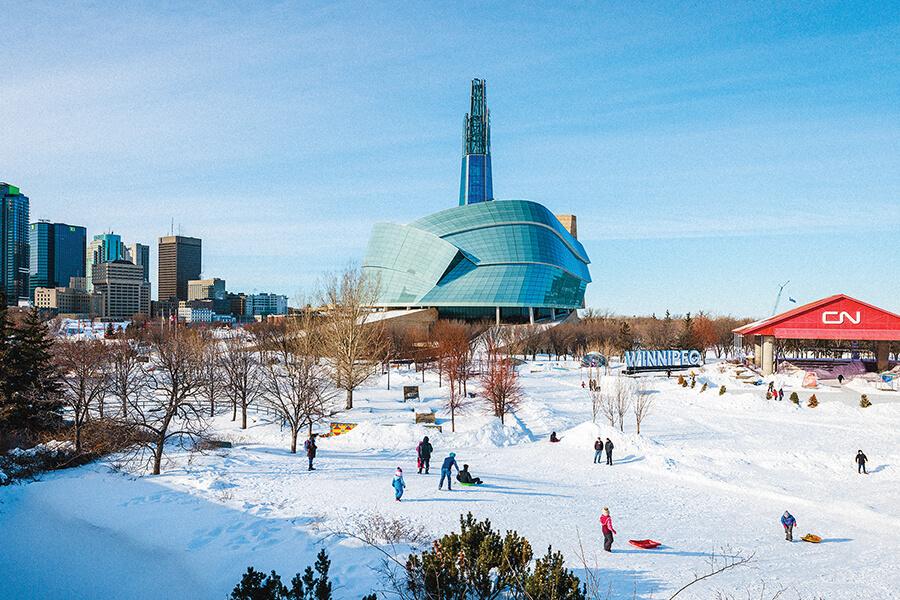 People skate at the Forks with the Canadian Museum for Human Rights in the background.