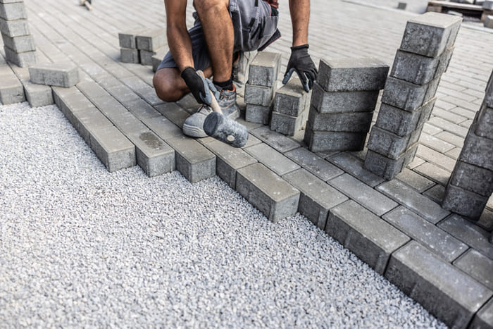 tradie layering bricks in the driveway