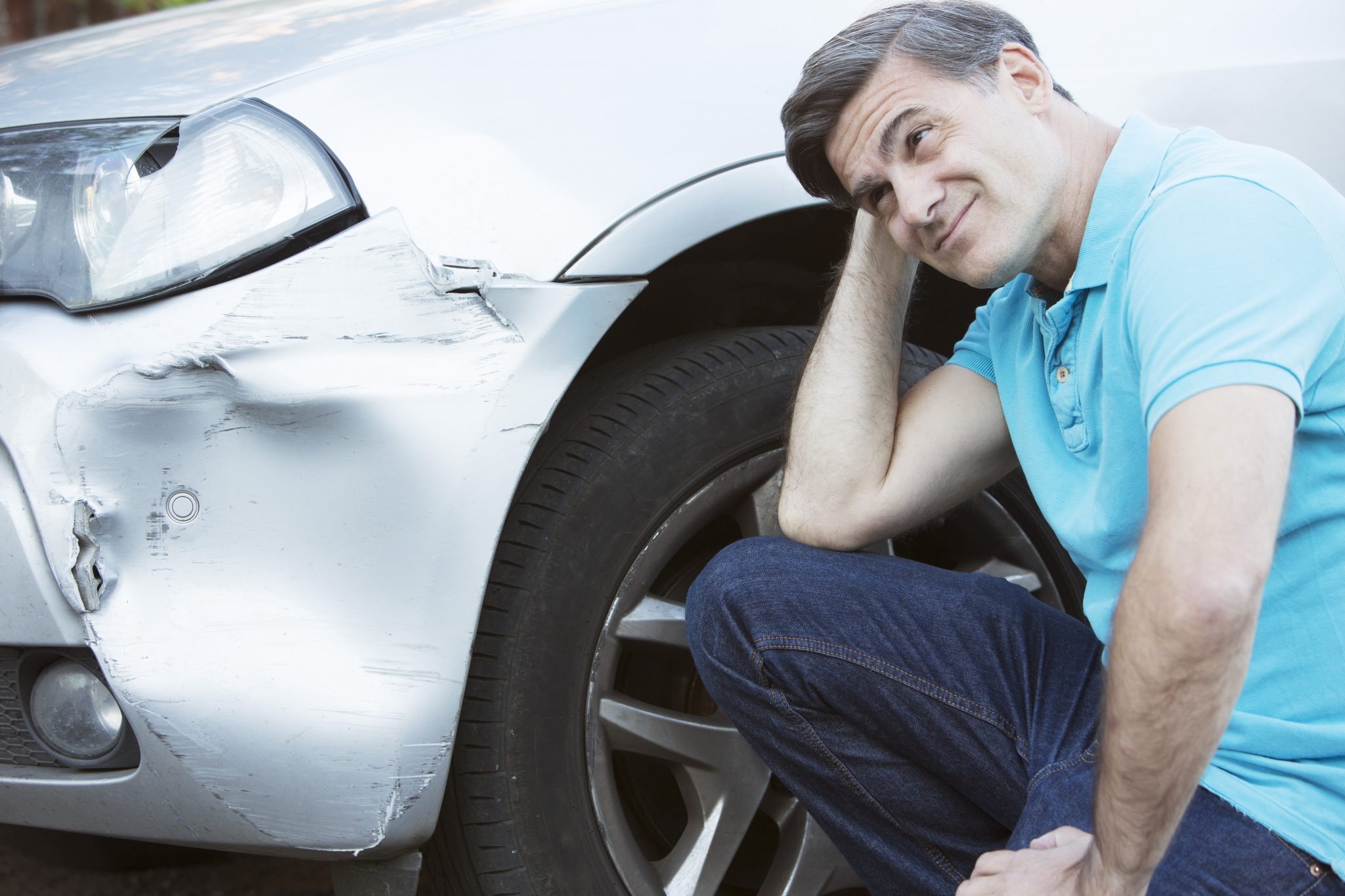 Unhappy Driver Inspecting Damage After Car Accident