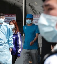 Hospital workers and visitors wearing masks pass by a precaution against the MERS, Middle East Respiratory Syndrome, virus at a quarantine tent for people who could be infected with the MERS virus at Seoul National University Hospital in Seoul, South Korea, Wednesday, June 3, 2015. South Korea on Tuesday confirmed the country's first two deaths from MERS as it fights to contain the spread of a virus that has killed hundreds of people in the Middle East.(AP Photo/Ahn Young-joon)