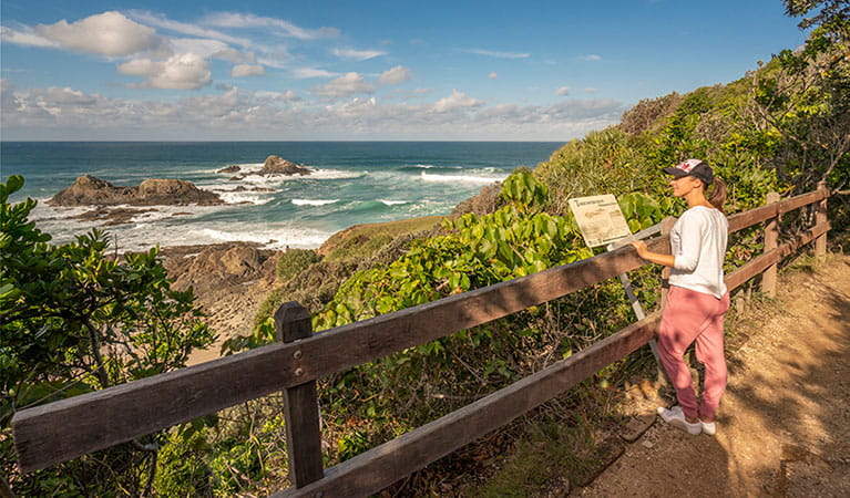 A woman reading signage along Three Sisters walking track in Broken Head Nature Reserve. Photo: John Spencer &copy; OEH