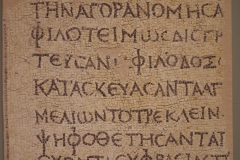 Mosaicked inscription dedicated by a Neikstratos to his father, who was a benefactor of Patrae and held public office. Dated to the 2nd century CE. Archaeological Museum of Patras.