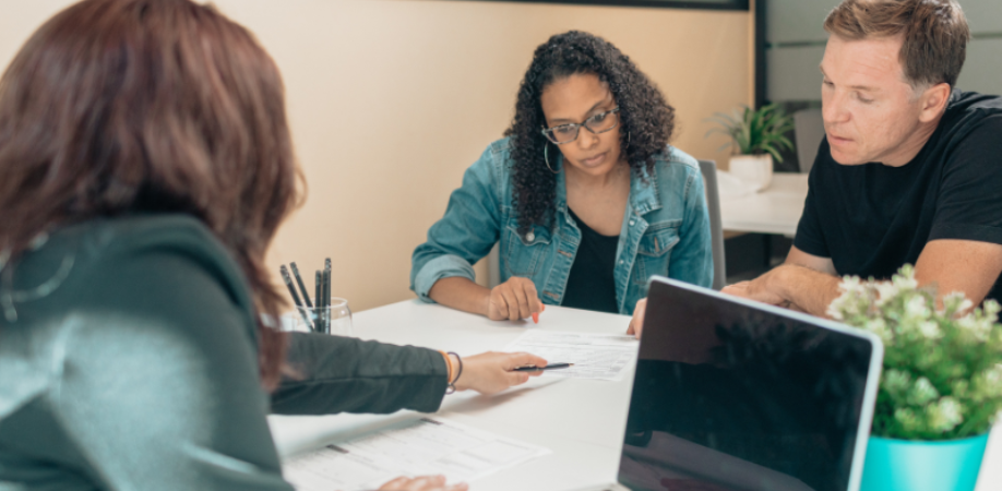 Three people reviewing documents at table