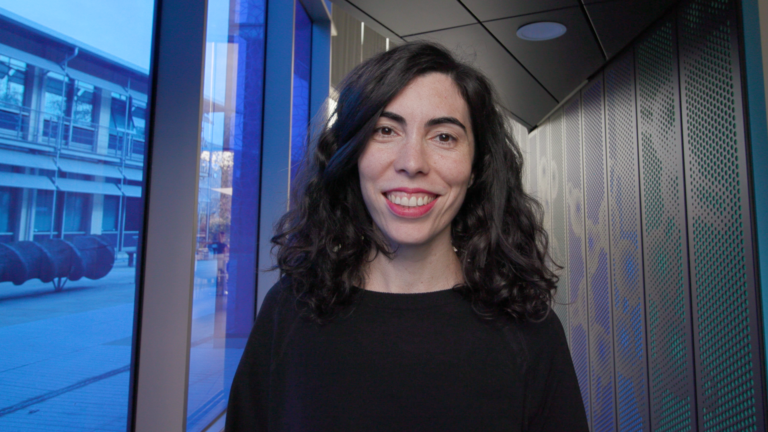 Laura smiling inside the Sulston building on the Wellcome Genome Campus