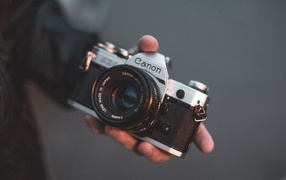 Старый фотоаппарат  Canon в руке 