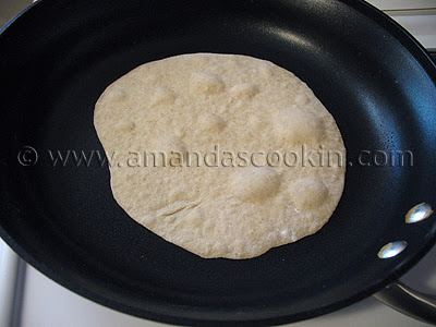 A close up photo of a low fat homemade tortilla being cooked in a skillet.