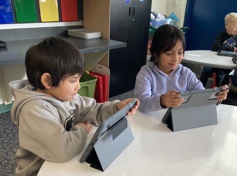 two students coding on iPads