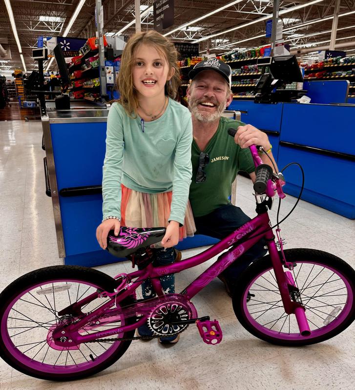 girl and dad with bicycle prize
