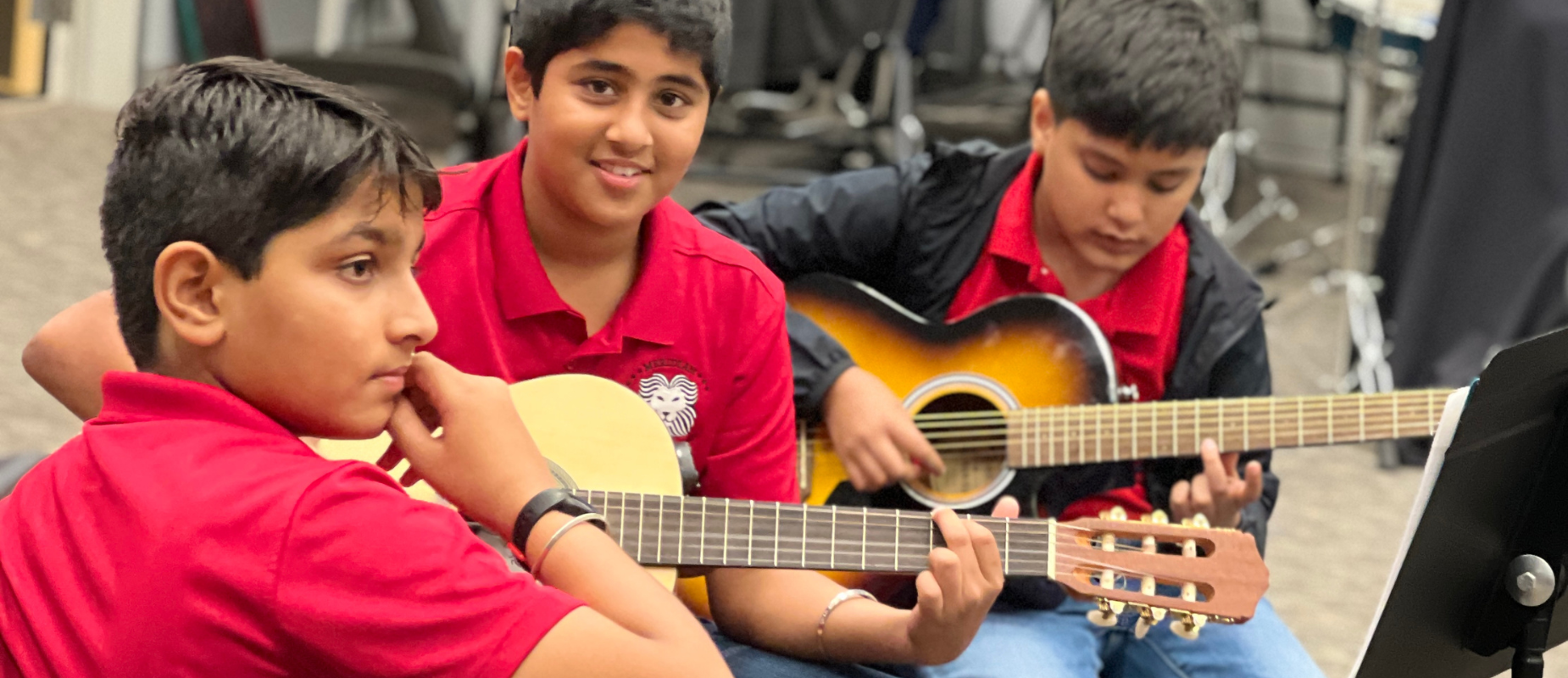 Students play guitars in music class