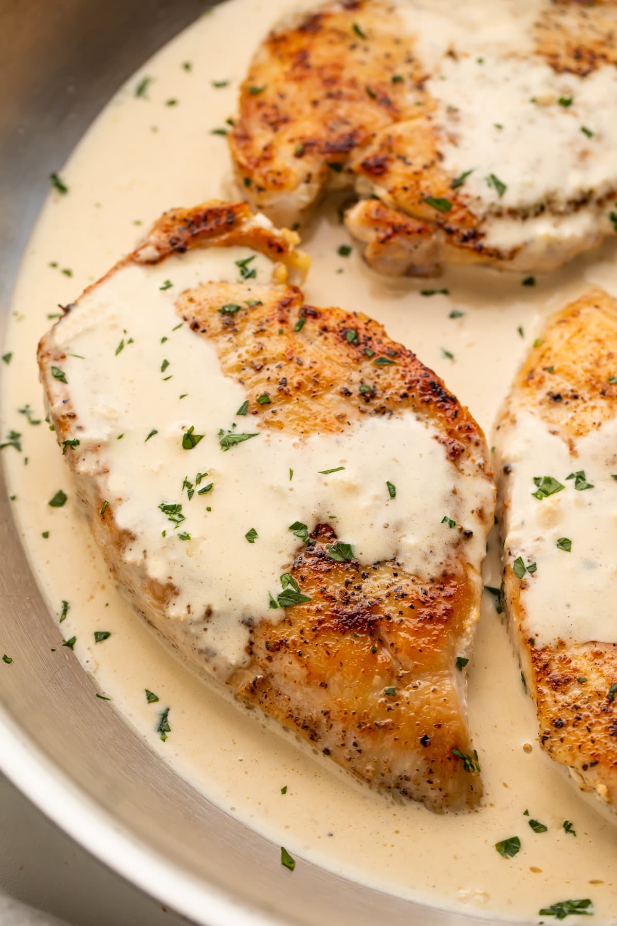 Cream cheese garlic chicken in a skillet with cream cheese sauce.