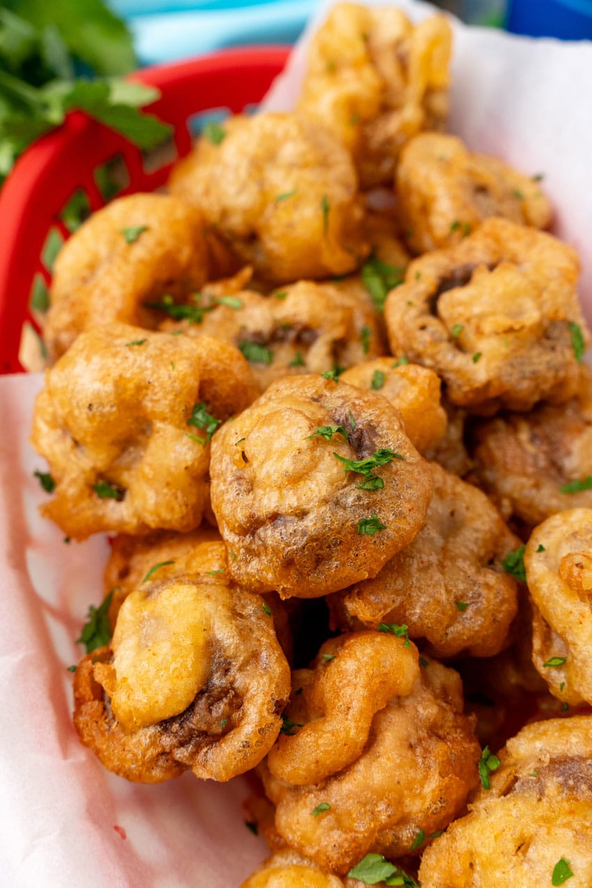 beer battered fried mushrooms in a parchment paper lined red food basket