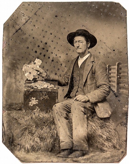 ca. 1860-70s, [tintype portrait of a man fanning some paper currency with a pile of gold coins]