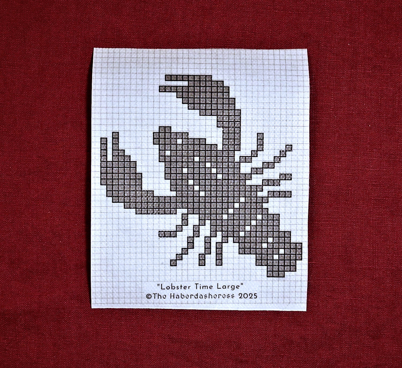 Photo of a white patch of interfacing/paper with a gridded pattern of a lobster printed on it