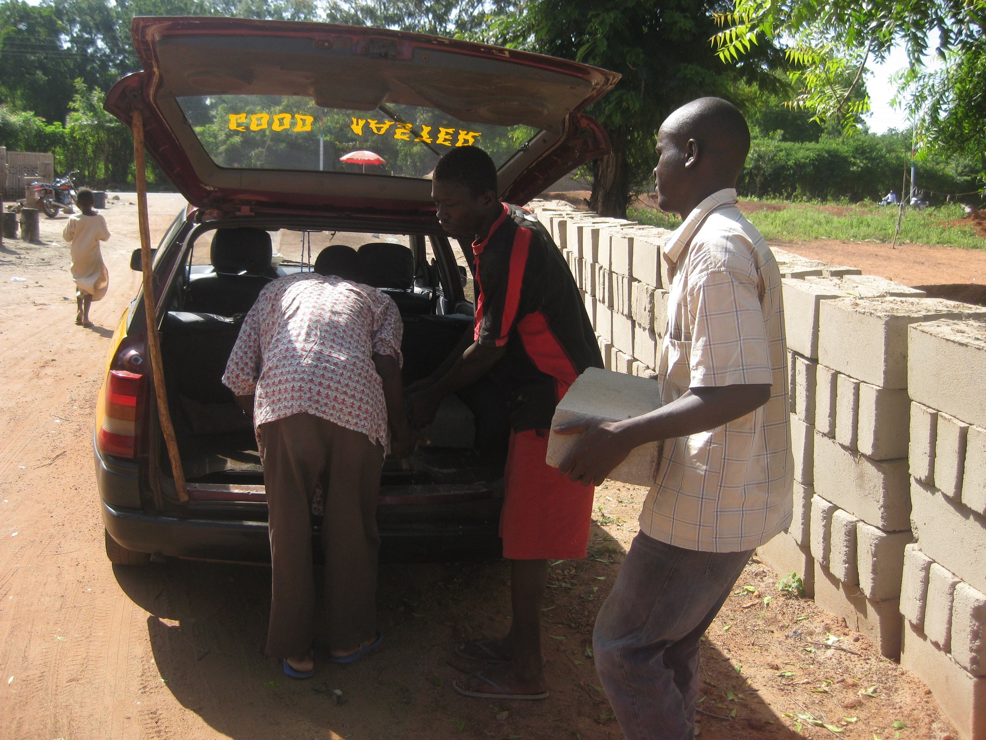 Loading up the taxi with bricks, cement, and sand to bring to Jarigu