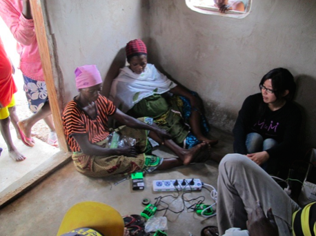 Linda explains to the women how to connect the batteries and chargers.